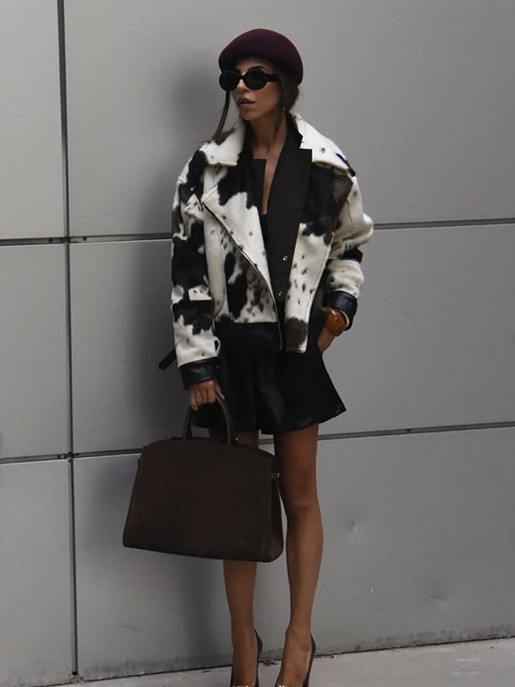 Women short padded biker jacket made of faux fur in cow print with contrast leather trim EVA-US