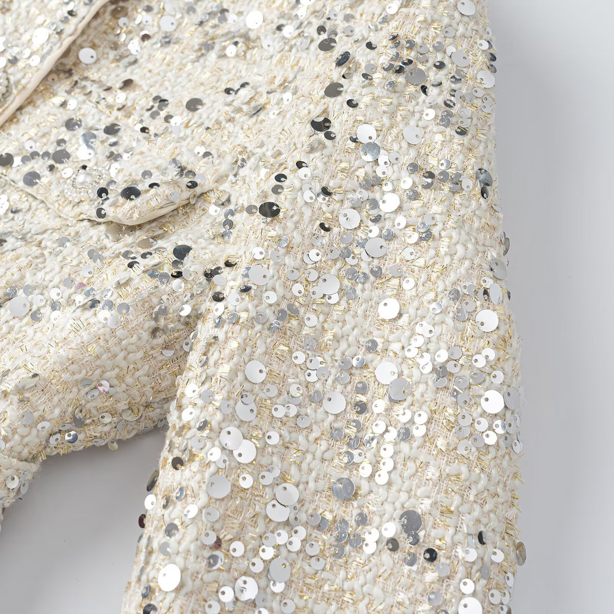 Women's short jacket made of bouclé with sequin trim, decorative pearl buttons, and a belted waist EVA-US