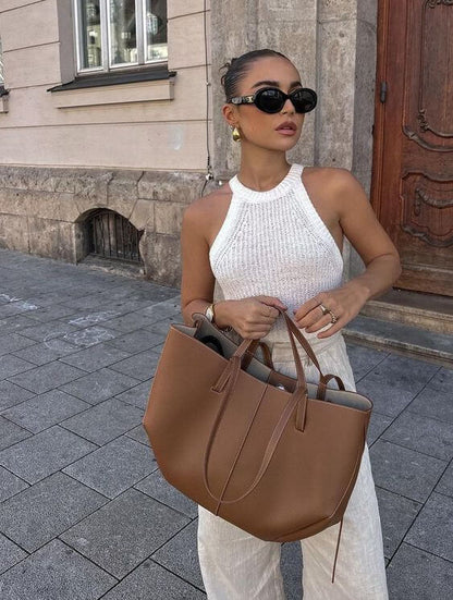 Frau, die eine braun ledertasche in einem street-style-setting hält