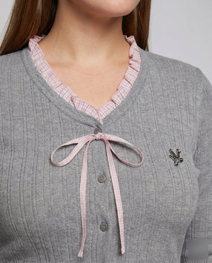 Women's long sleeve blouse with playful ruffled hem and decorative loop design - Chichicherry